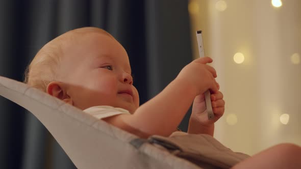 Child Watching TV in Living Room Cute Baby Boy Holding Tv Remote Sitting in Rocking Chair