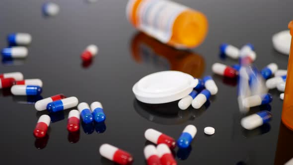 Prescription drug antibiotics falling down in slow motion with pill bottles among the medicine capsu