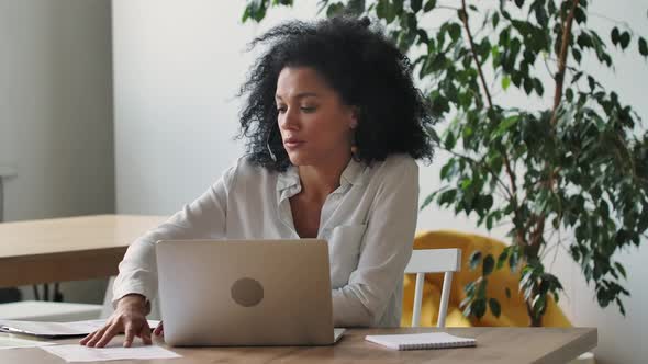 Portrait of a Young African American Woman Talking on Video Conference Call Using Laptop and Headset