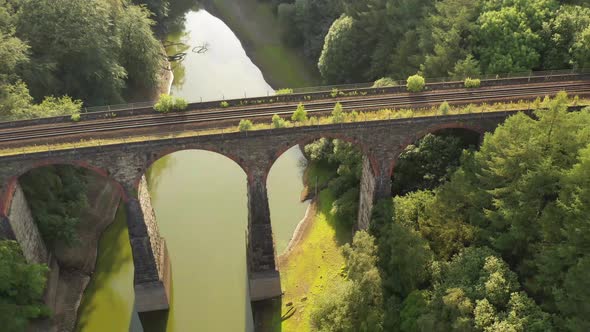 A flying shot over a railway bridge over a lake
