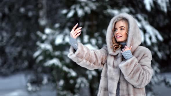 Fashionable Lady Posing Taking Selfie in Fur Coat Use Mobile at Forest