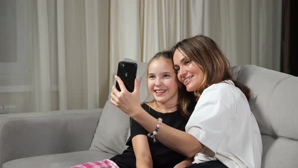 Mother and Teen Daughter Talk on Videocall Sitting at Home