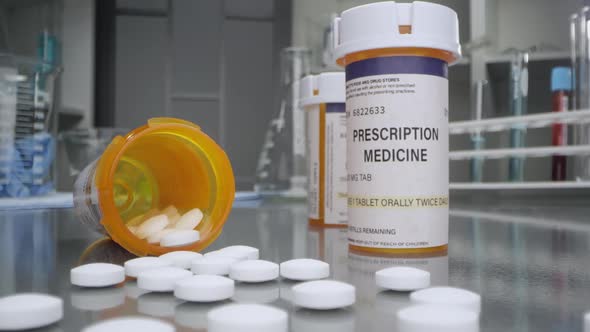 Prescription bottle and pills in medical lab poured out