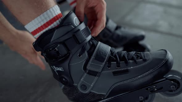 Active Teenager Putting on Roller Skates at Skate Park