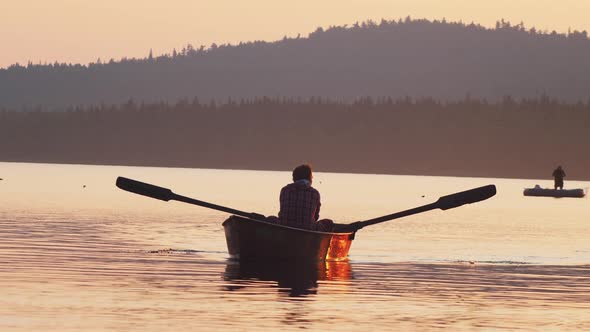 Man Sailing on River on the Boat Using Paddles