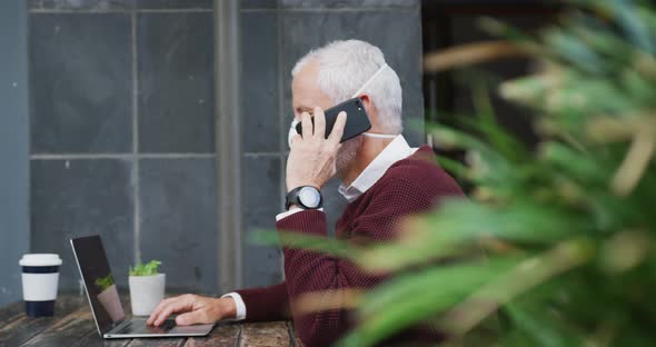 Caucasian man out and about in a coffee wearing a face mask against coronavirus