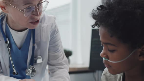 Pediatrician Giving Pill Organizer to Boy