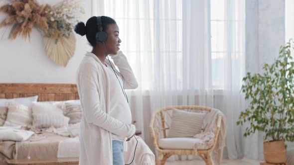 African Single Future Mother Pregnant Afro Woman Listening to Music on Headphones Enjoying Favorite