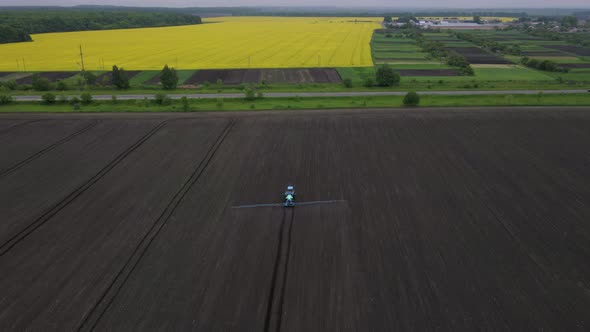 Powerful Agricultural Tractor Apply Mineral and Nitrogen Fertilizer on Ground at Field