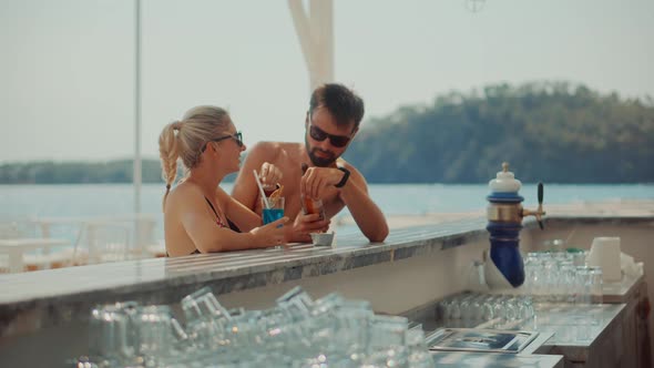 Romantic Couple Drinking Beer On Bar Counter. Honeymoon Lovers Vacation Travel In Greek Resort.