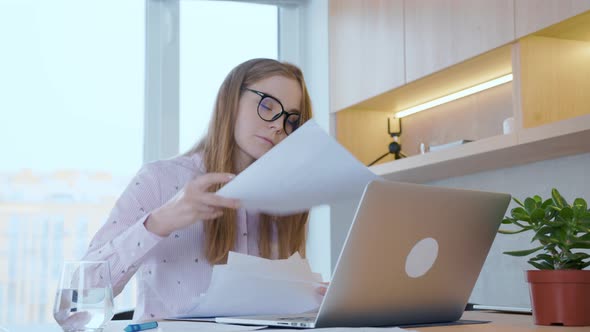 Young woman in glasses communicates on a conference call, through a laptop