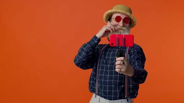 Senior Grandfather Traveler Blogger in Sunglasses Taking Selfie on Smartphone Video Call Online