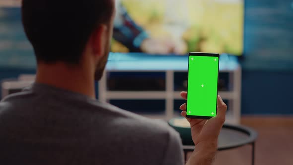 Person Holding Mobile Phone with Green Screen Vertically