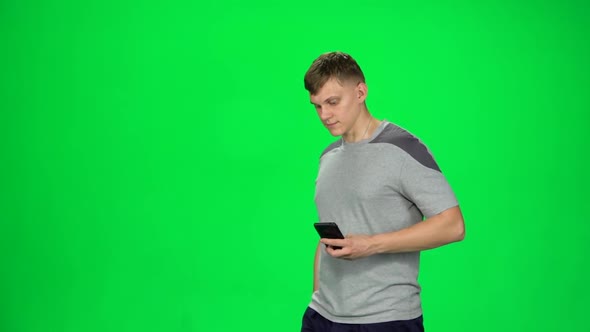 Young Man Watches the Time on the Phone and Starts To Run. Chroma Key. Slow Motion