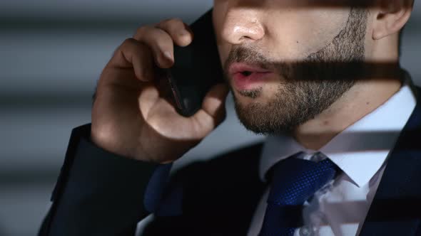 Closeup Face Business Man in Tie Suit Discussing Deal Talking Smartphone at Evening Room Jalousie