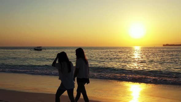 Sexy smiling ladies travelling spending quality time on beach on summer white sandy and blue 4K back