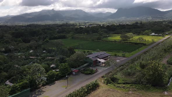 Cinematic aerial footage orbiting and revealing Arenal volcano and Cerro chato in background with he