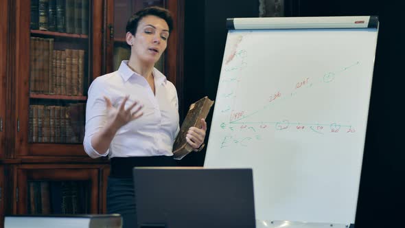 Female Teacher Explaining Chart Data To Remote Students