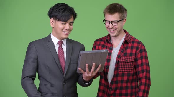 Young Handsome Asian Businessman and Young Scandinavian Businessman Working Together