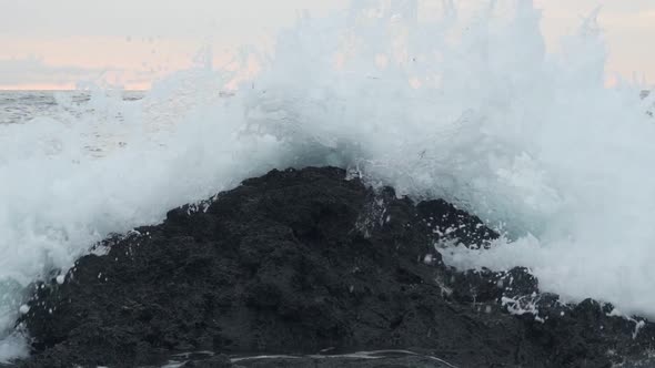 Seascape view of ocean waves crashing on the rocky shore, in Watamu Beach, Kenya, at dusk