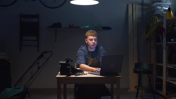 Craftsman Working on a Laptop in His Garage. Quarantine