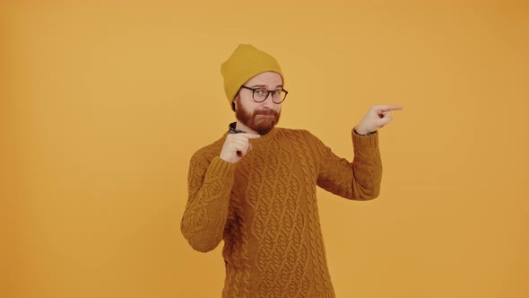 Funny Guy Pointing with His Fingers to the Right Side of the Screen  Orange Background