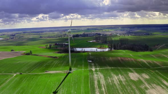 Wind turbine on green field in spring, aerial view