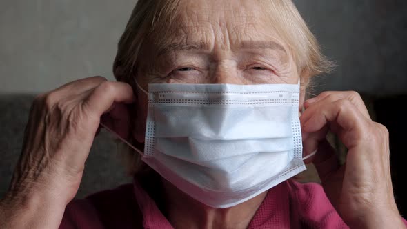 Happy Elderly Caucasian Woman Take Off Protective Medical Mask On Her Face