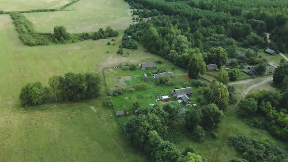 Village In The Middle Of The Forest. Rural Landscape. Roofs Of Houses Are Visible Among The Trees