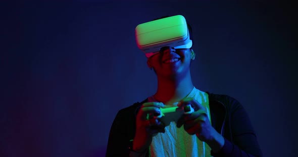 Young Asian man playing metaverse virtual reality digital technology game.