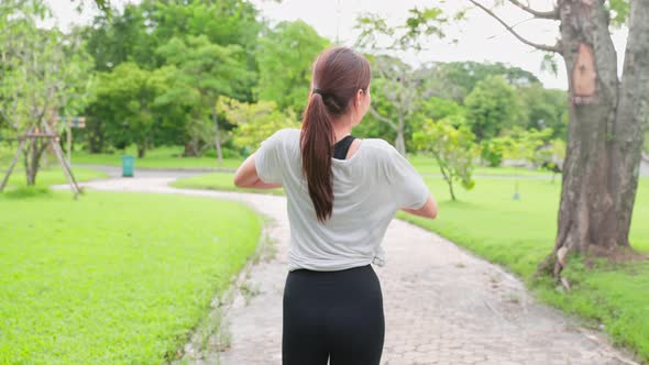 Asian young sport woman stretch body warm up before exercise in park.