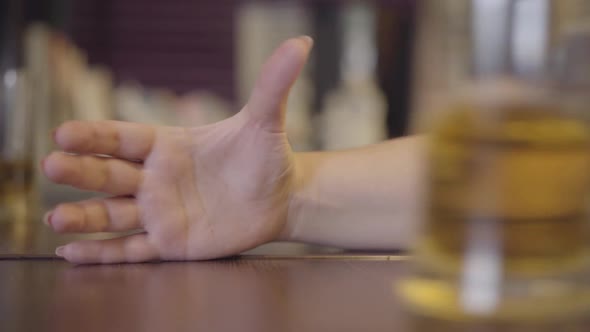 Glass of Light Beer Slowly Sliding on the Table and Falling Into the Hand of a Girl