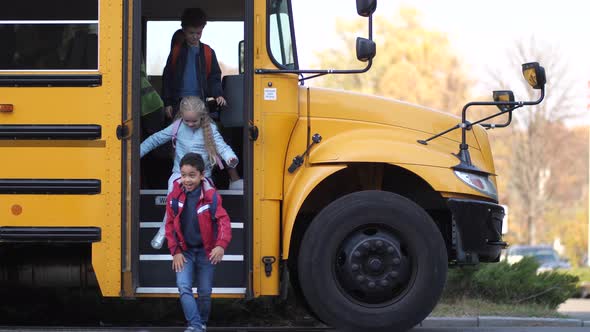 Female School Bus Driver Saying Bye To Schoolkids