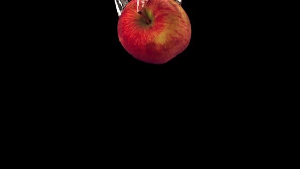 Super Slow Motion One Red Apple Falls Under the Water with Air Bubbles