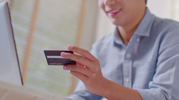 Close up hand of business man using credit card for pay online shopping on computer laptop