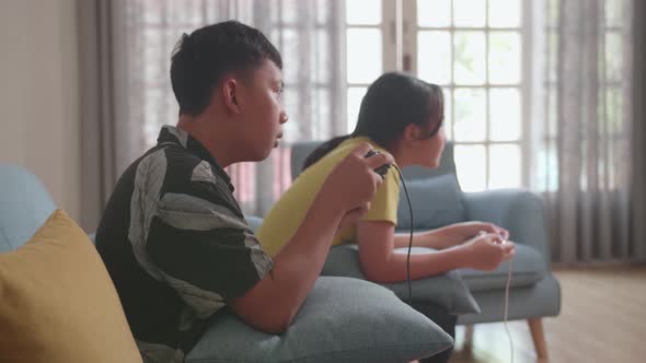 Asian Children With Joystick Game Play Video Game At Home