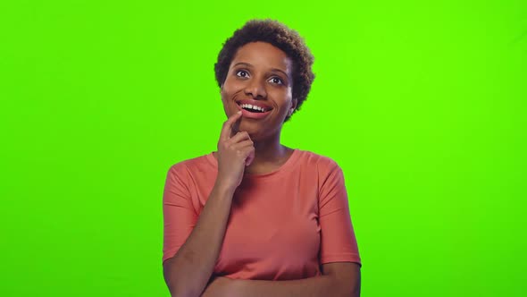 African American Woman Is Dreaming in Peach T-shirt on Green Screen Chroma Key