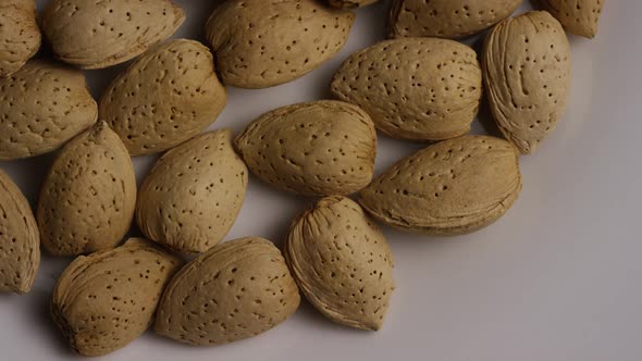 Cinematic, rotating shot of almonds on a white surface 