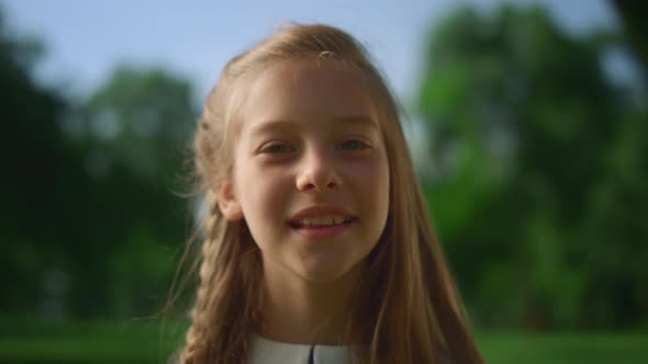 Smiling Blonde Little Girl Posing Alone in Park Closeup