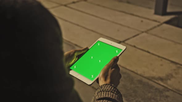 Man is Using Tablet in Landscape Mode on Lap Outdoors at Sunny Day