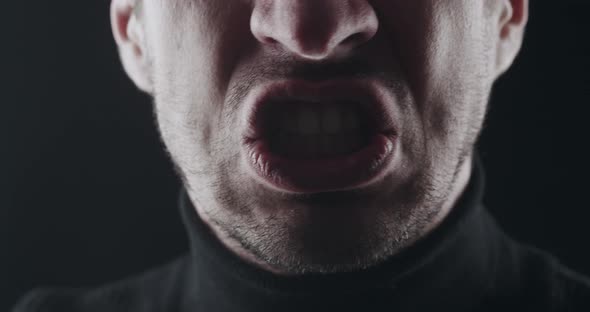 Closeup of Aggressive Man's Mouth Screams and Threatens with Violence