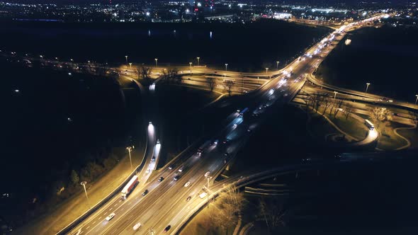 Illuminated road intersection at night in Warsaw, Poland. Aerial drone view. Reveal, dolly out.