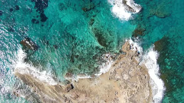 Aerial View of Foamy Turquoise Waves Crashing on Deserted Rocks on Cyprus Resort. Camera Approaches