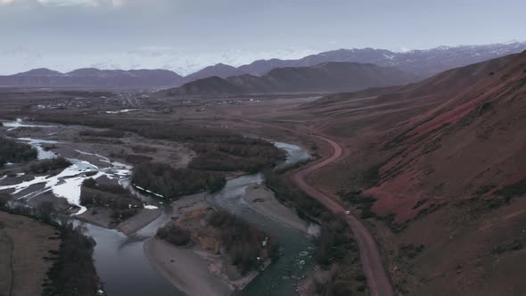 A Wonderful Breathtaking Flight Over a Valley with Branching Rivers a Road with a Small White Car