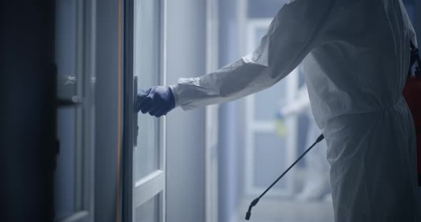 Men in Hazmat Suits Disinfecting Doors