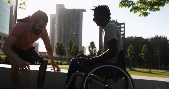 Multiethnic friends with disability greeting each other at city park