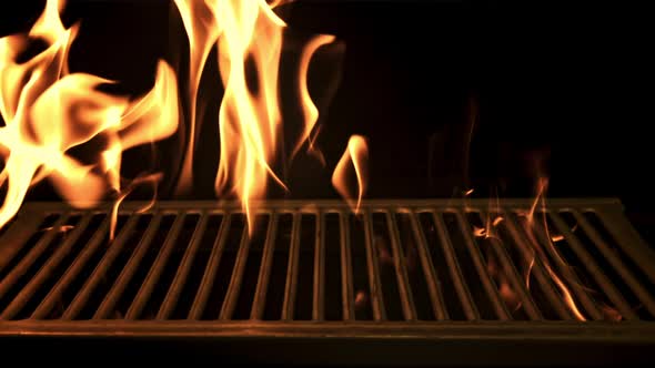 A Bright Flame of Fire Burns Through the Grill