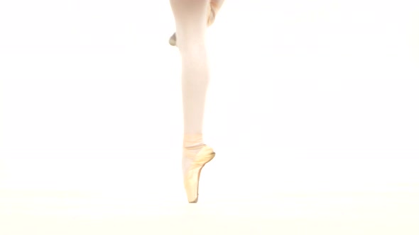 Young Ballerina Dancing, Closeup on Legs and Shoes, Standing in Pointe Position.