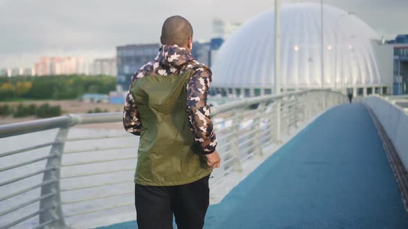 African American Professional Sportsman Sprinting on Urban Bridge