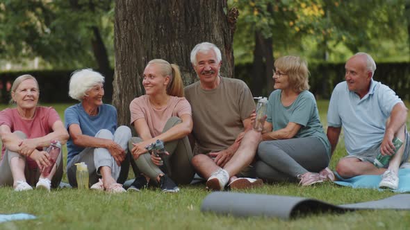 Portrait of Joyous Fitness Coach and Senior People in Park